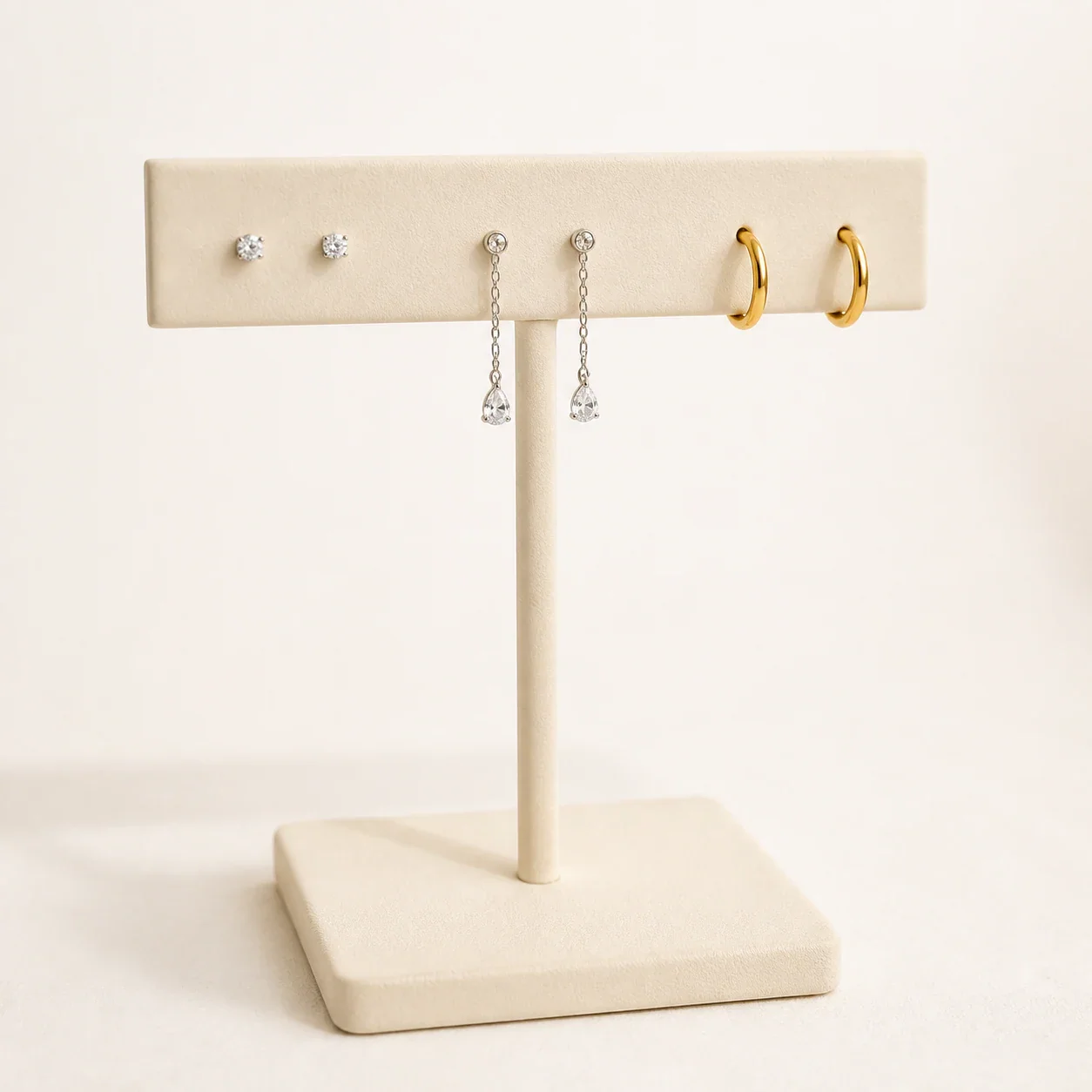 Illustrative stud, drop and hoop earrings on an ivory display stand