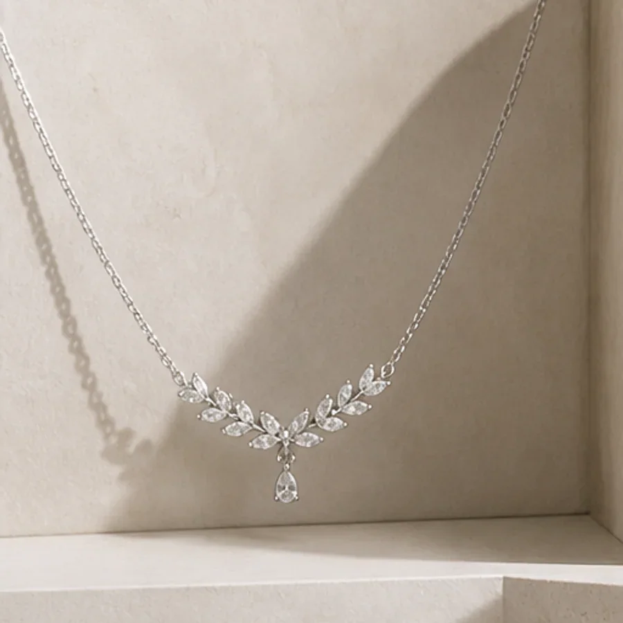 Illustrative silver-tone necklace with a leaf motif and clear drop stone