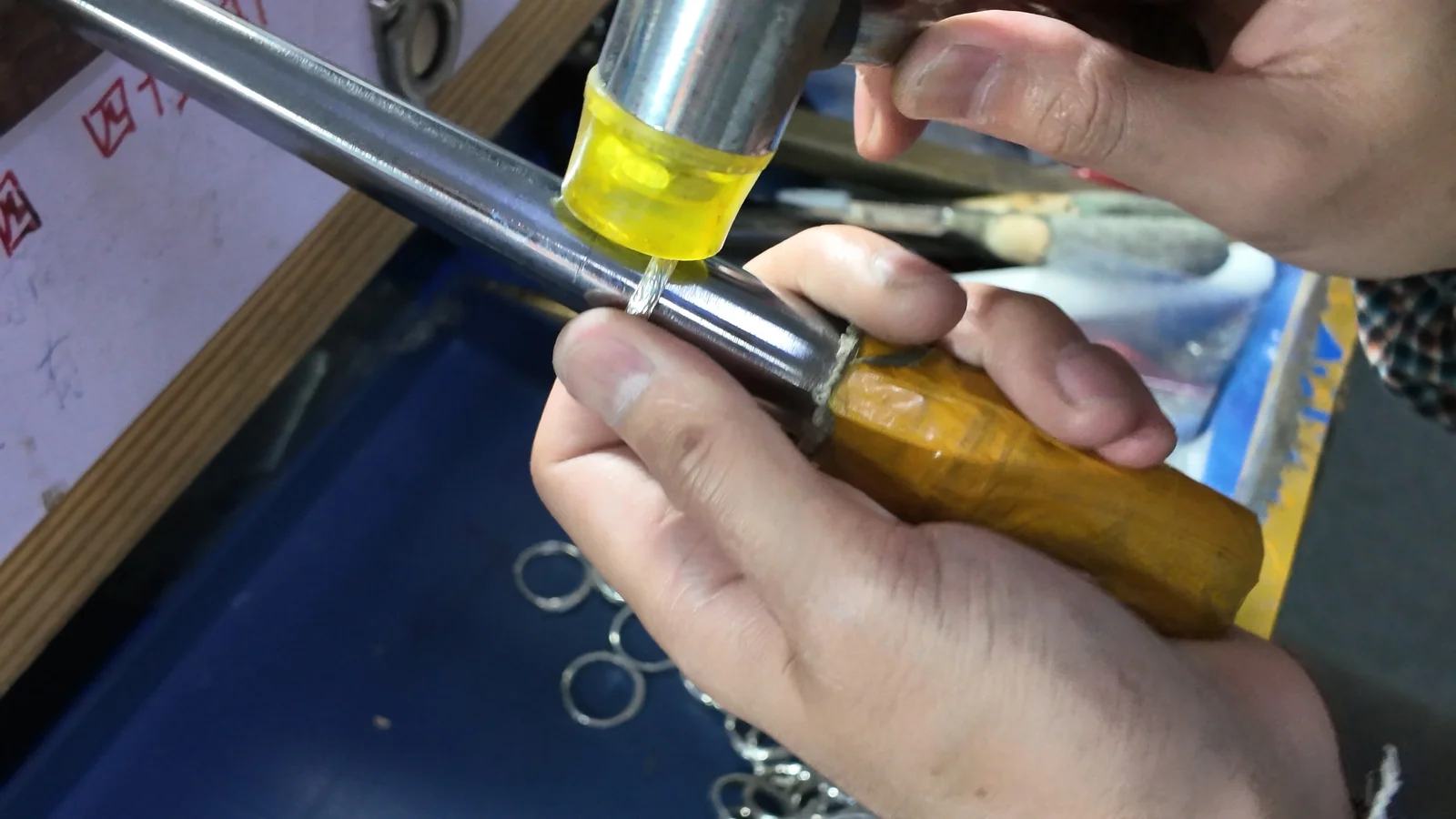 A silver ring being shaped on a mandrel