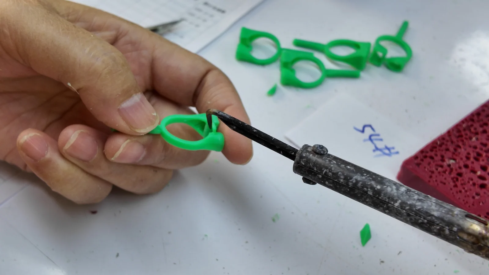 A jewelry wax pattern being refined by hand